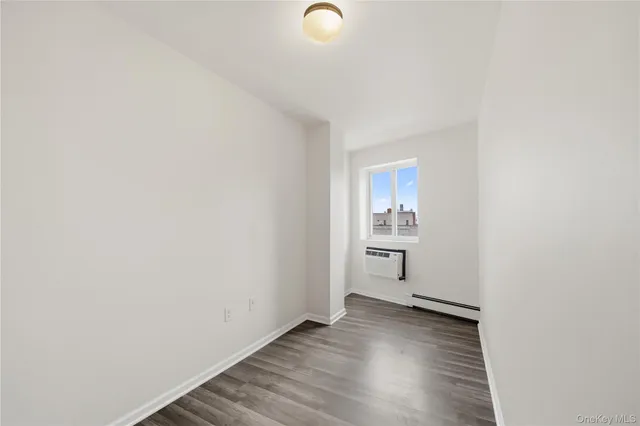 a view of a room with wooden floor and window