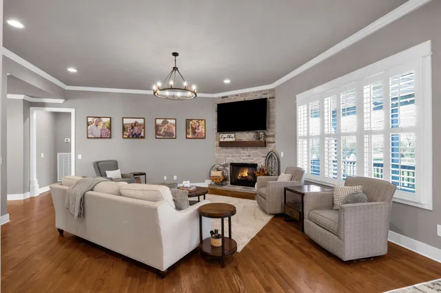 a living room with furniture a fireplace and a flat screen tv