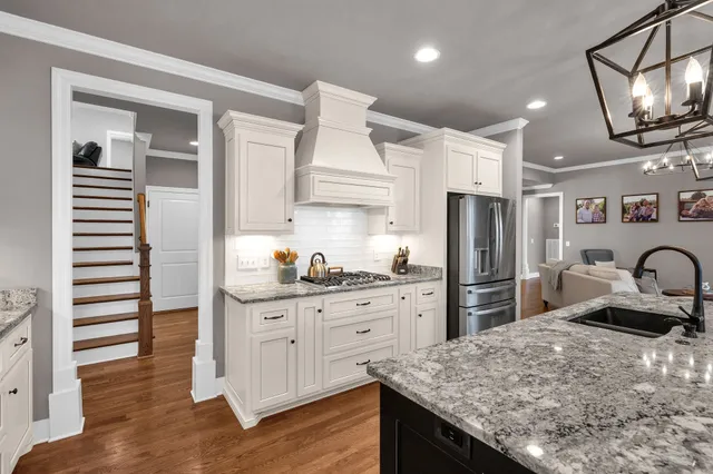 a kitchen with granite countertop a sink stainless steel appliances and cabinets