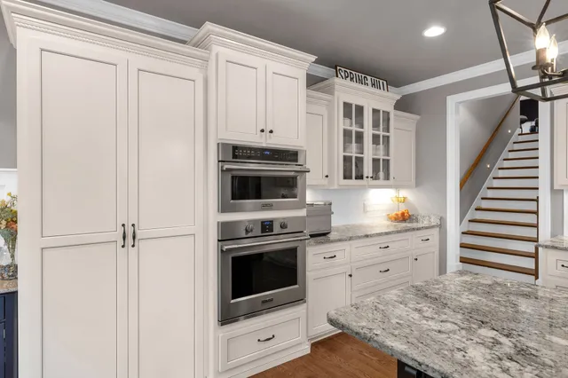 a kitchen with granite countertop white cabinets and white appliances