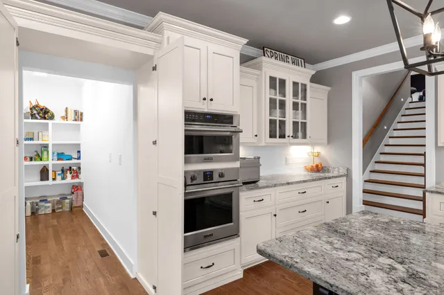 a kitchen with cabinets and wooden floor