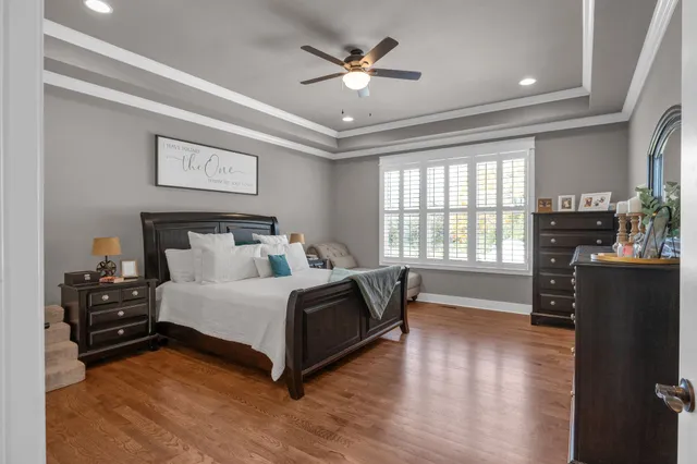a spacious bedroom with a bed and wooden floor