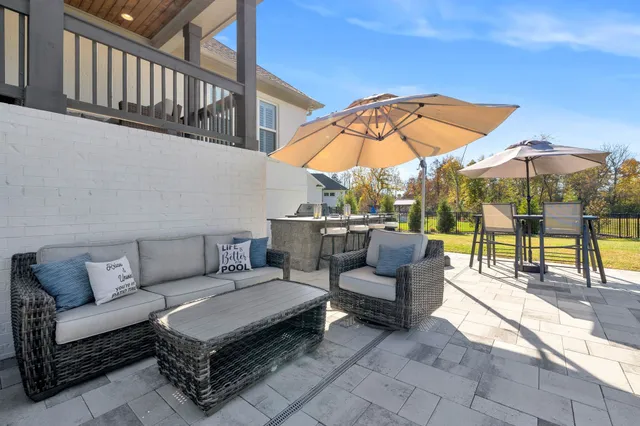 a view of a swimming pool with a lounge chair and a small yard