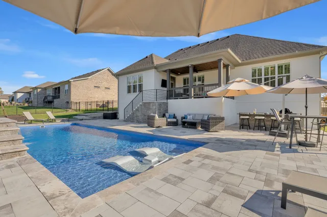a view of a patio with table and chairs under an umbrella