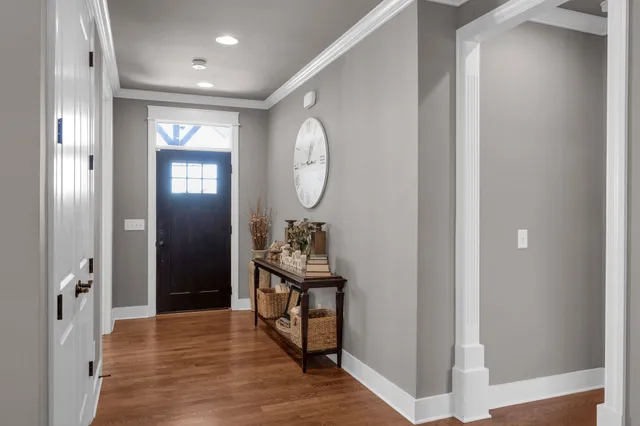 a view of a hallway with wooden floor and windows