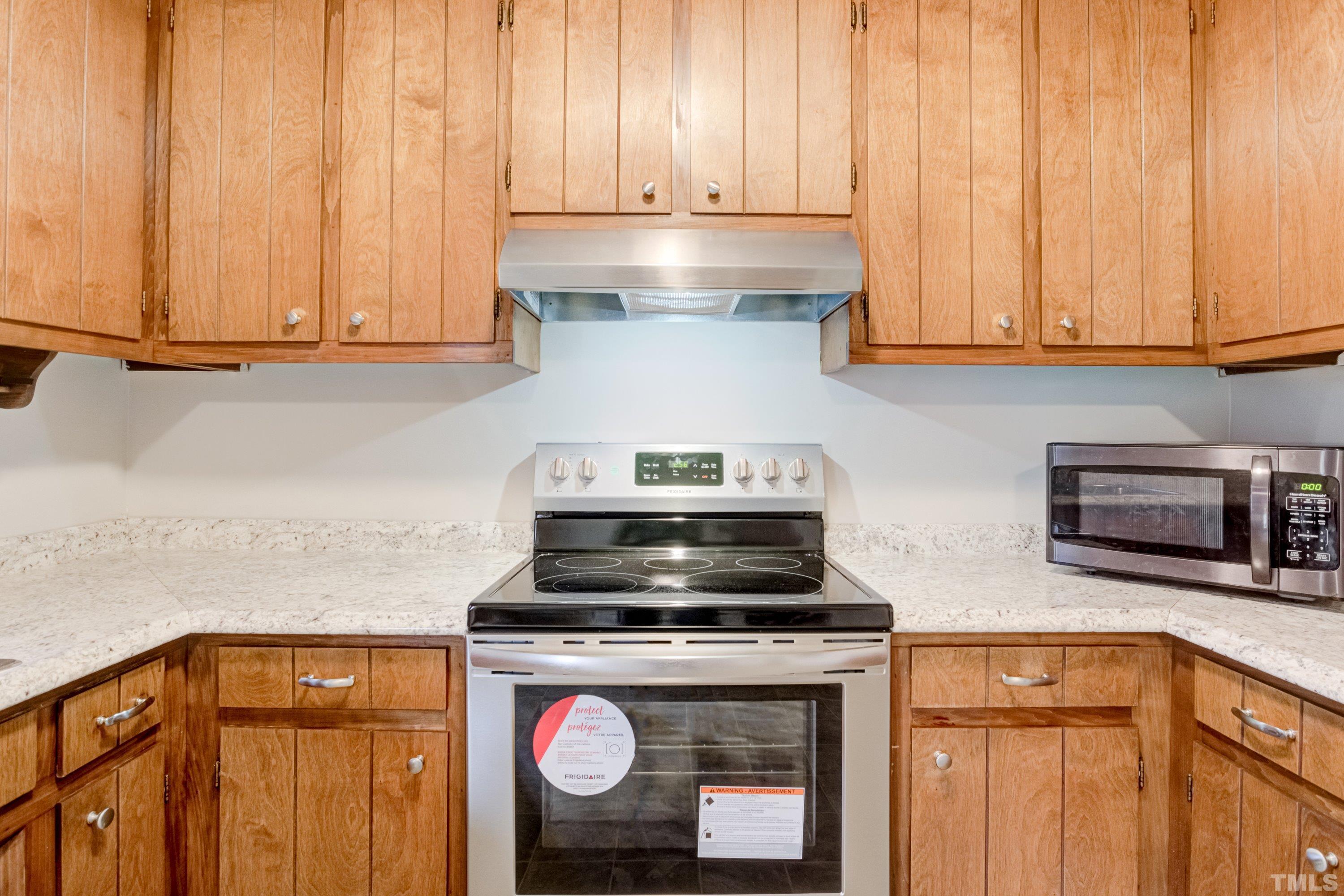 5149 Shield Circle Raleigh, NC 27603 - Photo 11 of 41 a kitchen with granite countertop wood cabinets and stainless steel appliances