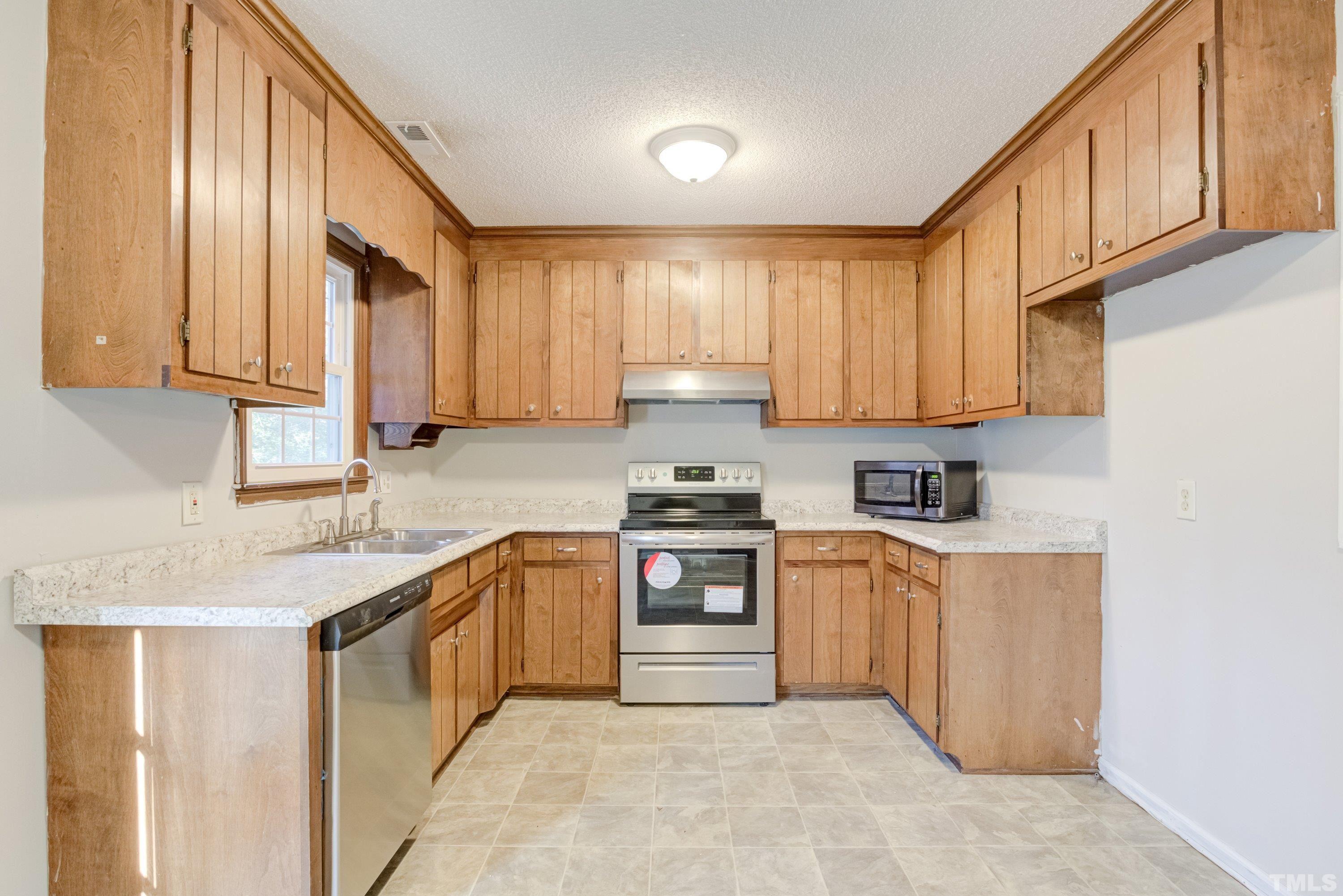 5149 Shield Circle Raleigh, NC 27603 - Photo 12 of 41 a kitchen with stainless steel appliances granite countertop a sink stove and cabinets