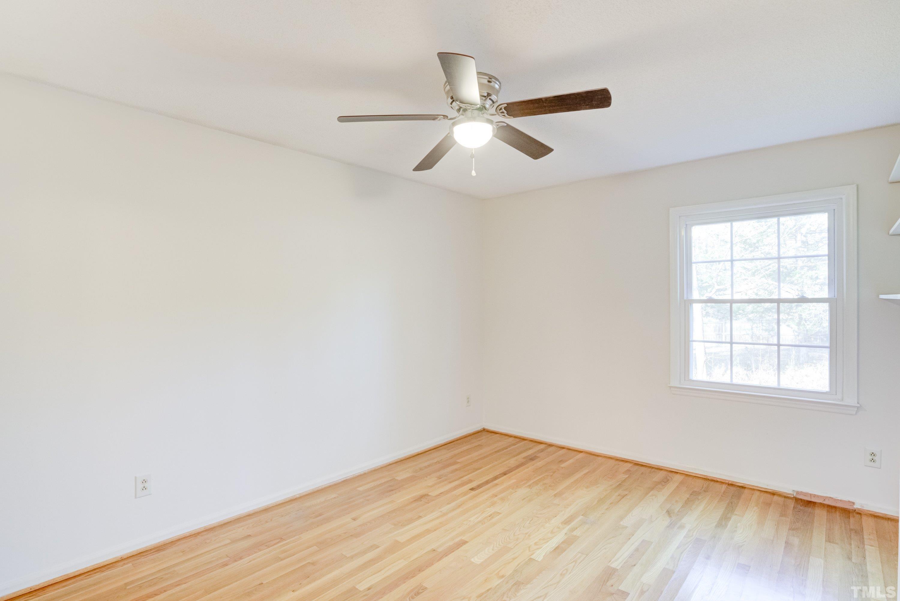 5149 Shield Circle Raleigh, NC 27603 - Photo 18 of 41 an empty room with wooden floor fan and windows