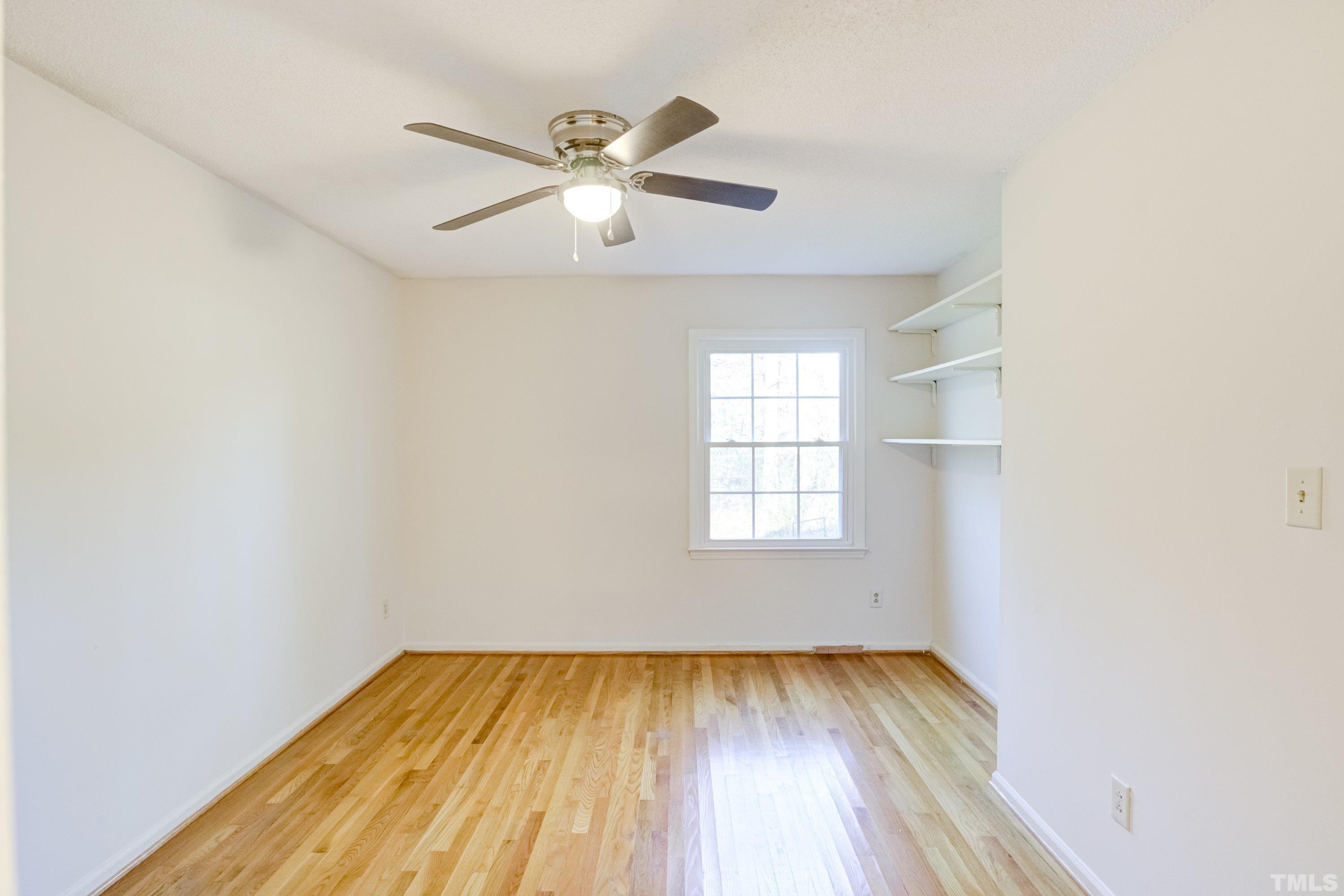 5149 Shield Circle Raleigh, NC 27603 - Photo 20 of 41 an empty room with wooden floor fan and windows