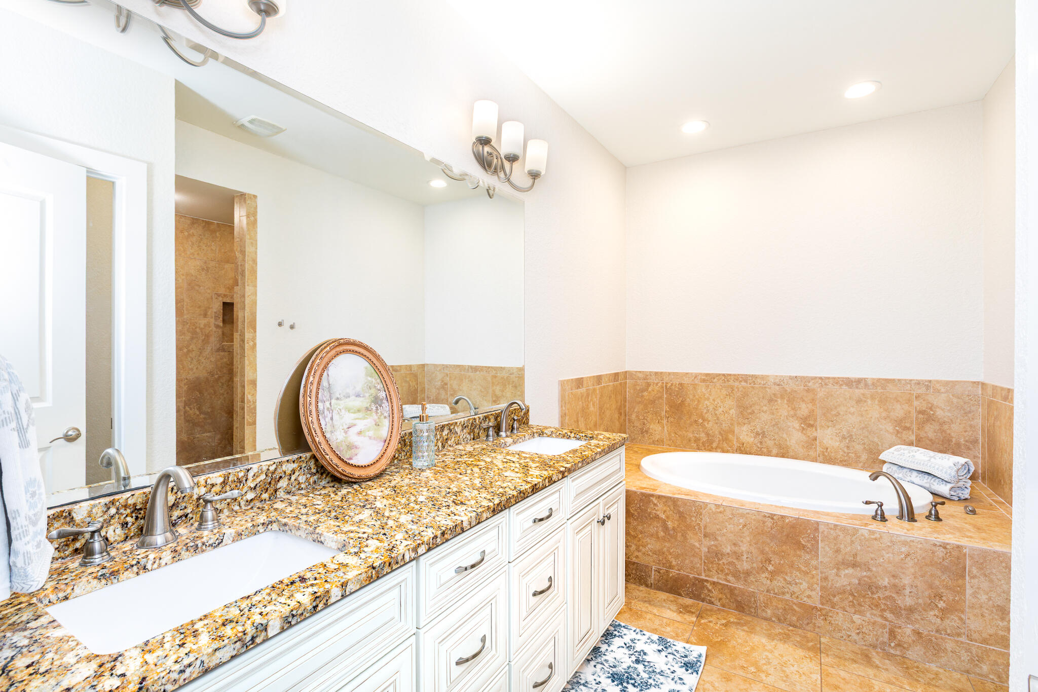 995 Airport Road, Unit 54 Destin, FL 32541 - Photo 18 of 31 a bathroom with a granite countertop bathtub a sink and a mirror
