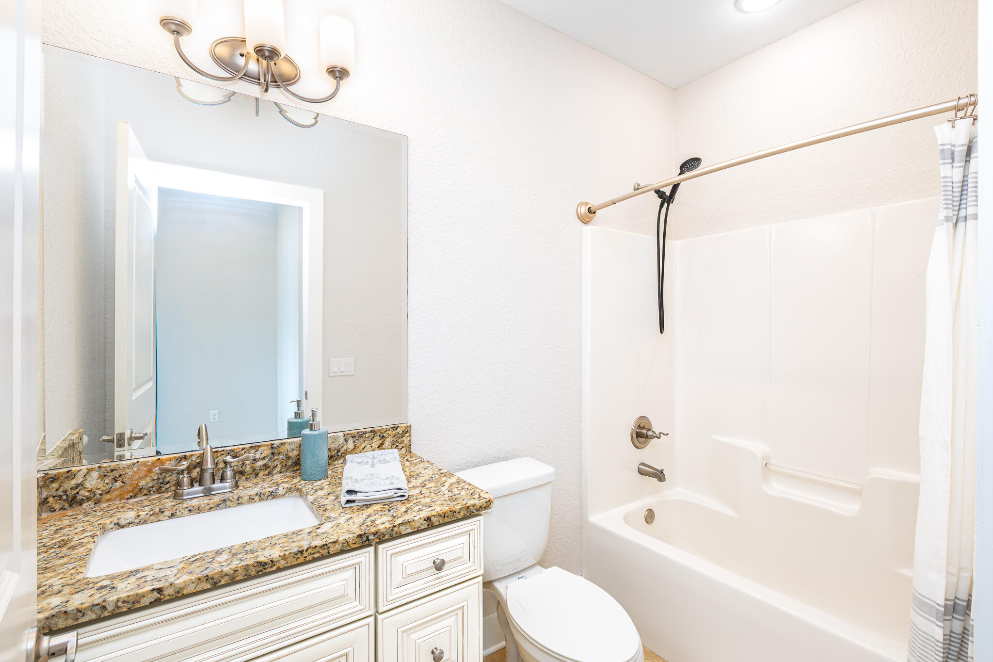 995 Airport Road, Unit 54 Destin, FL 32541 - Photo 28 of 31 a bathroom with a granite countertop sink mirror toilet and bathtub