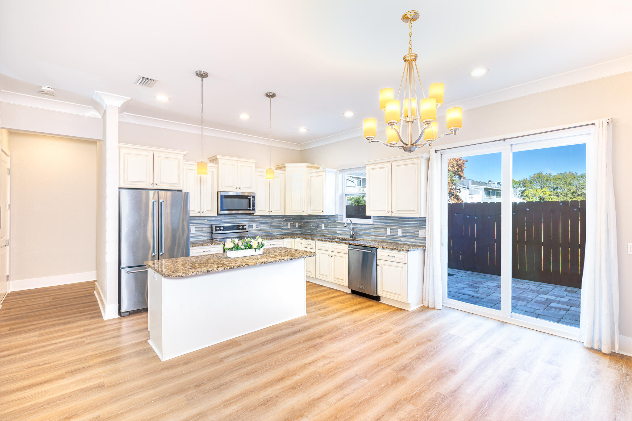 995 Airport Road, Unit 54 Destin, FL 32541 - Photo 5 of 31 a large kitchen with kitchen island a stove a sink dishwasher a refrigerator and a fireplace with wooden floor