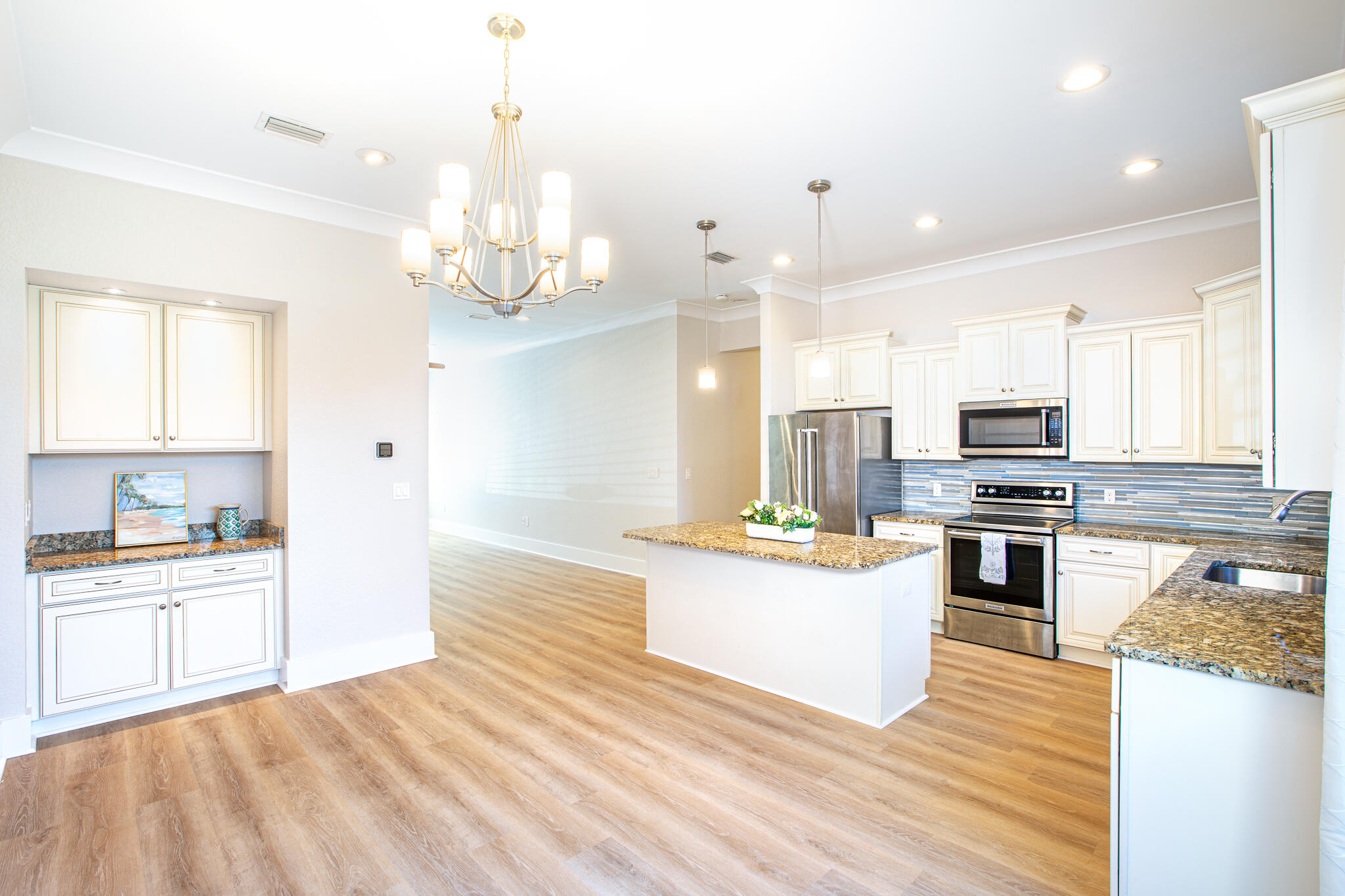 995 Airport Road, Unit 54 Destin, FL 32541 - Photo 8 of 31 a kitchen with stainless steel appliances kitchen island granite countertop a stove top oven a sink dishwasher a dining table and chairs with wooden floor
