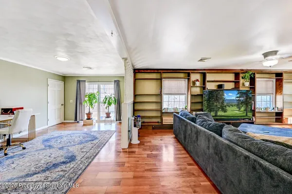a living room with furniture wooden floor and a kitchen view