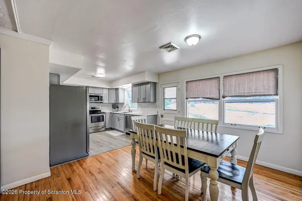 a kitchen with stainless steel appliances granite countertop a sink table and chairs