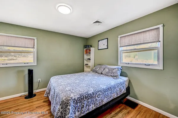 a bedroom with a bed and large windows