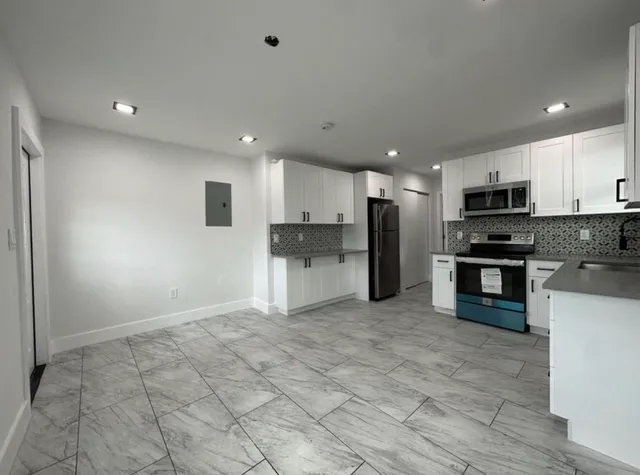 a kitchen with stainless steel appliances granite countertop a refrigerator and a stove top oven
