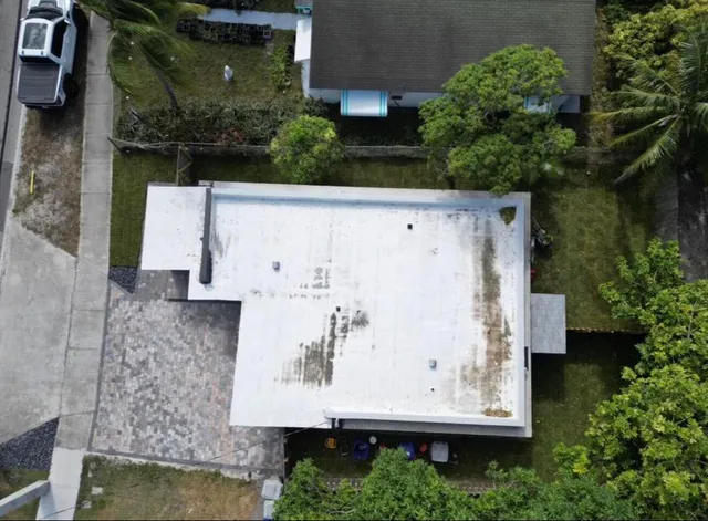 an aerial view of residential house with pool and trees