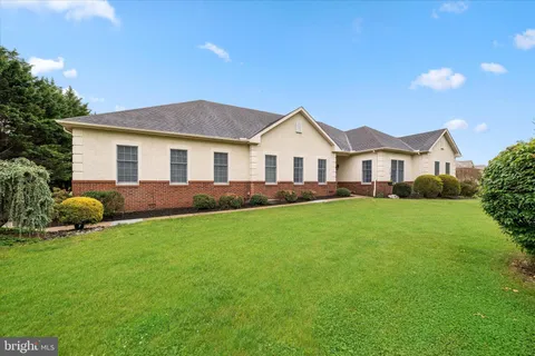 a front view of a house with a garden and yard