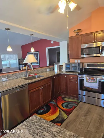 a kitchen with stainless steel appliances granite countertop a stove a sink and a microwave