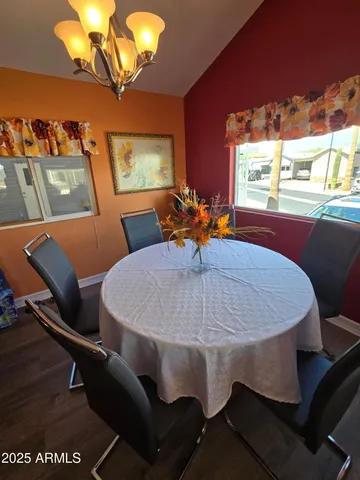 a view of a dining room with furniture a chandelier and wooden floor