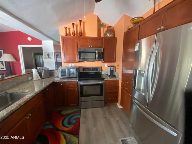 a kitchen with stainless steel appliances granite countertop a refrigerator and a stove