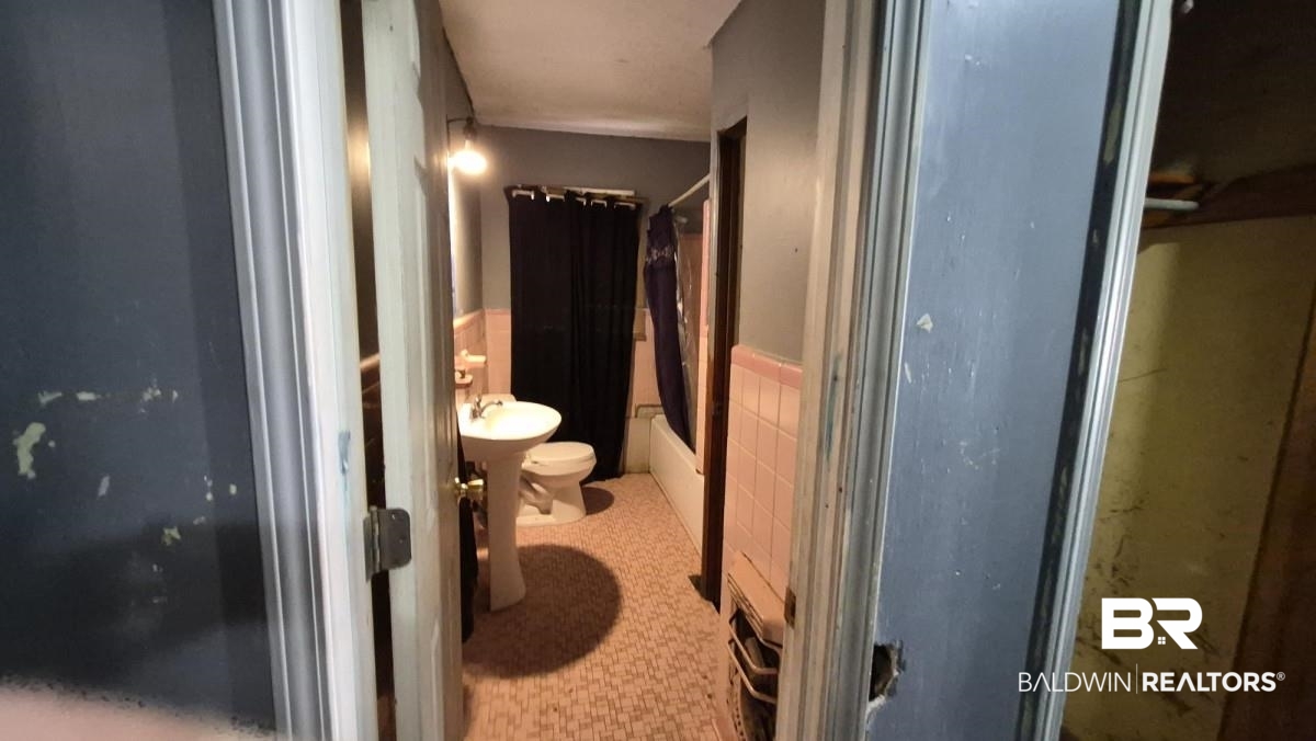 2207 Roberta Drive Mobile, AL 36617 - Photo 10 of 14 Full bath featuring wainscoting, shower / tub combo with curtain, and tile walls
