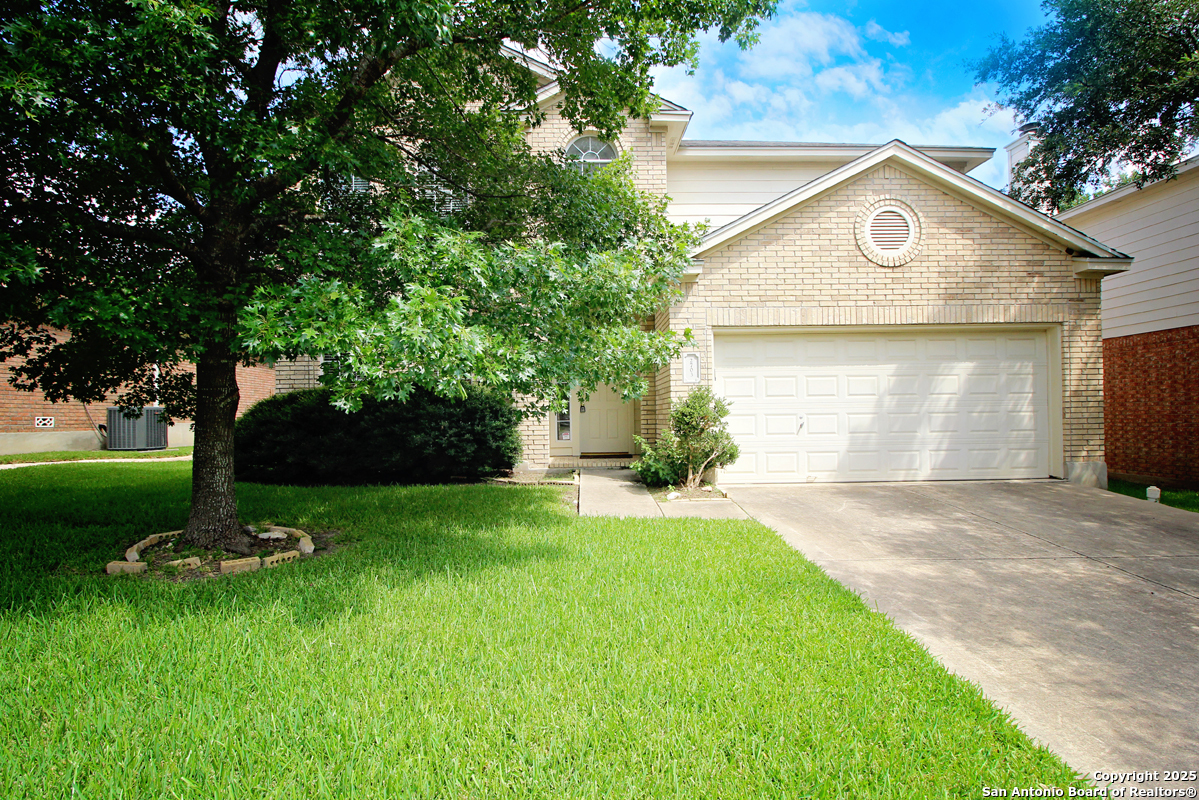 a front view of a house with a yard and trees