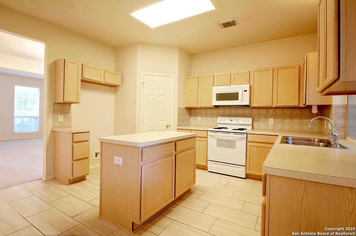 2703 Rio Brazos San Antonio, TX 78259 - Photo 13 of 34 a kitchen with a stove cabinets and a refrigerator