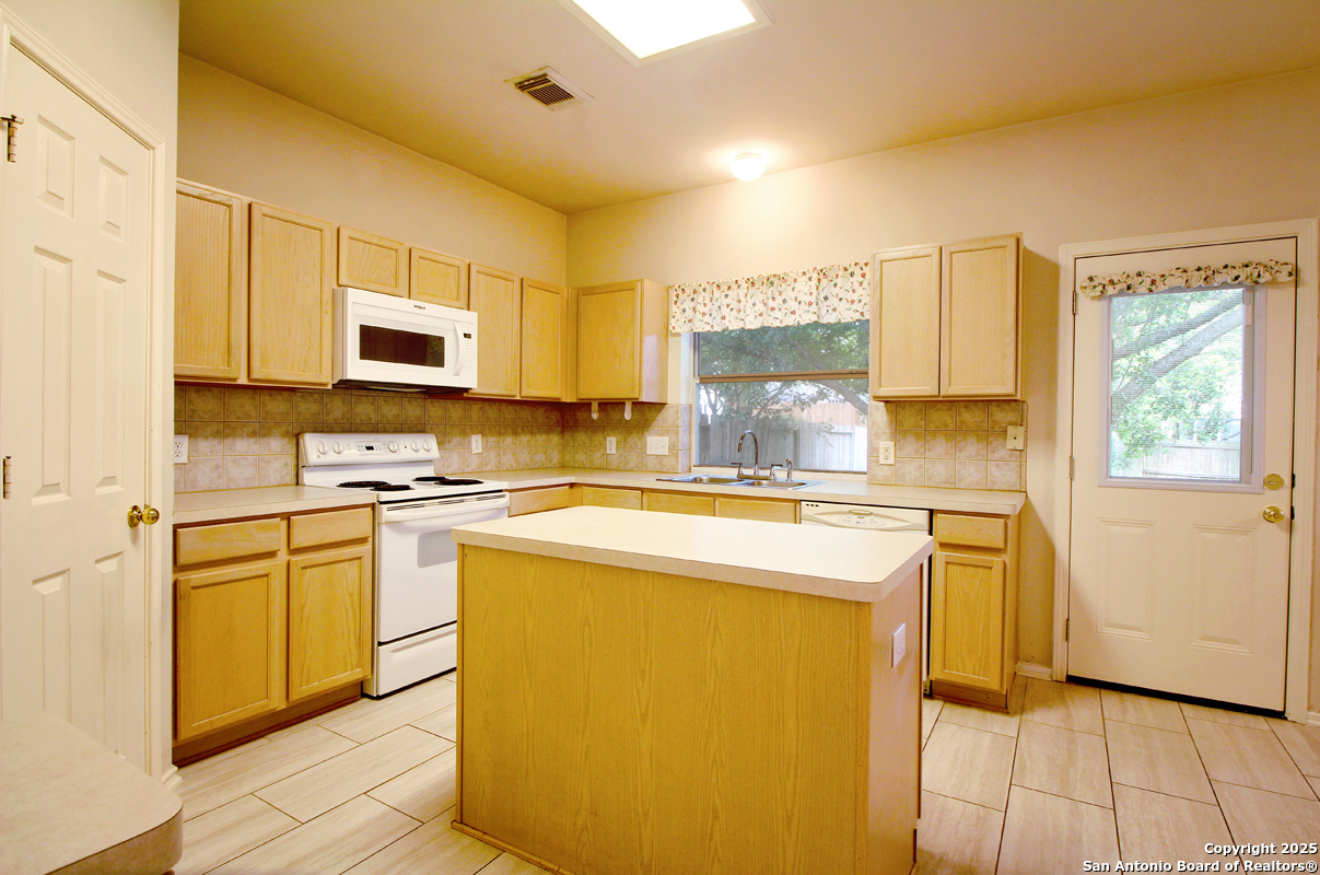 2703 Rio Brazos San Antonio, TX 78259 - Photo 16 of 34 a kitchen with stainless steel appliances granite countertop a stove a sink and a microwave