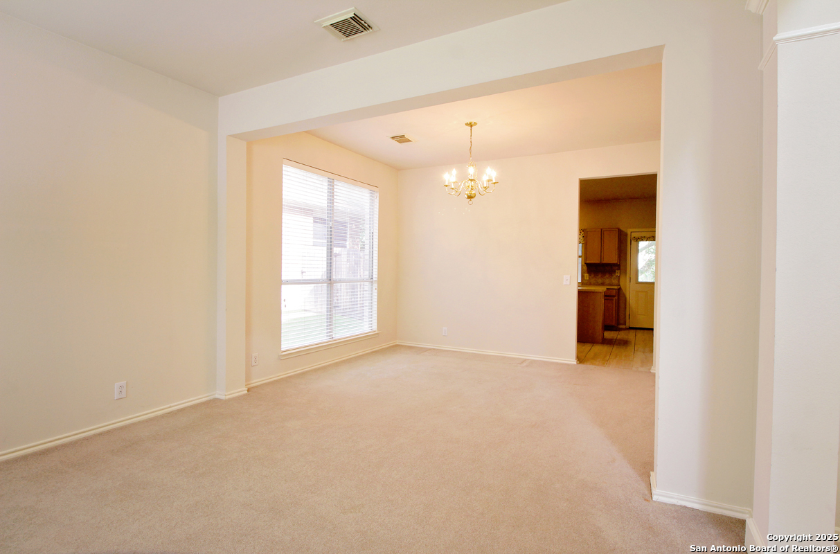 2703 Rio Brazos San Antonio, TX 78259 - Photo 7 of 34 an empty room with chandelier fan and windows