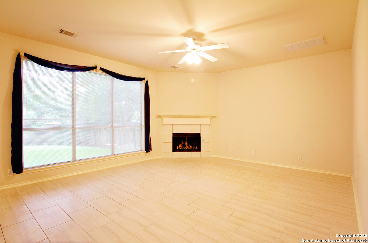 2703 Rio Brazos San Antonio, TX 78259 - Photo 8 of 34 a view of an empty room with a fireplace and a large window