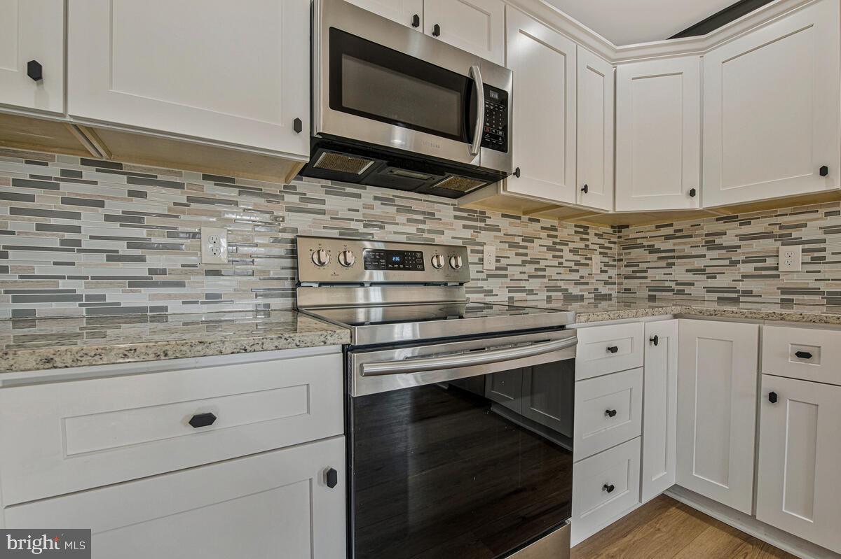 941 8th Street Pasadena, MD 21122 - Photo 12 of 41 a kitchen with stainless steel appliances granite countertop a stove microwave and cabinets
