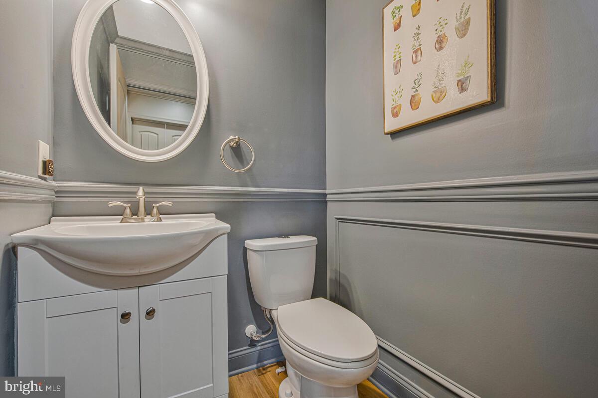 941 8th Street Pasadena, MD 21122 - Photo 18 of 41 a bathroom with a toilet a sink and mirror