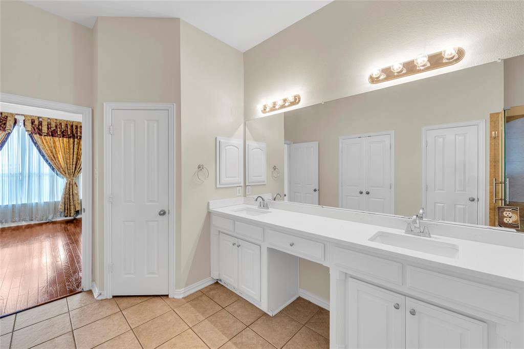 3920 Autumn Lane Bedford, TX 76021 - Photo 23 of 36 Double vanity featuring white cabinetry, integrated sinks, and polished chrome faucets