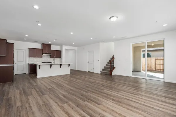 a view of kitchen with kitchen island stainless steel appliances wooden floor and center island