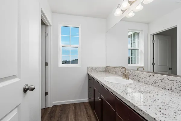 a bathroom with a granite countertop sink and a mirror
