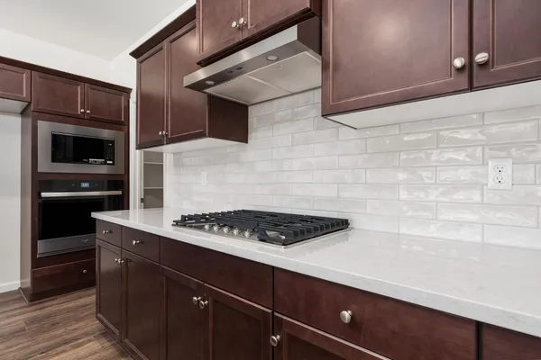 a kitchen with stainless steel appliances a stove and a microwave