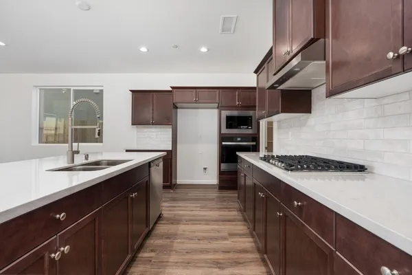 a kitchen with stainless steel appliances granite countertop a sink stove and cabinets