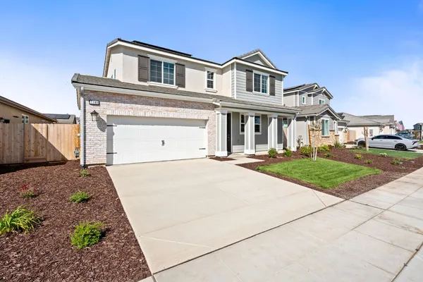 a front view of a house with a garden and patio
