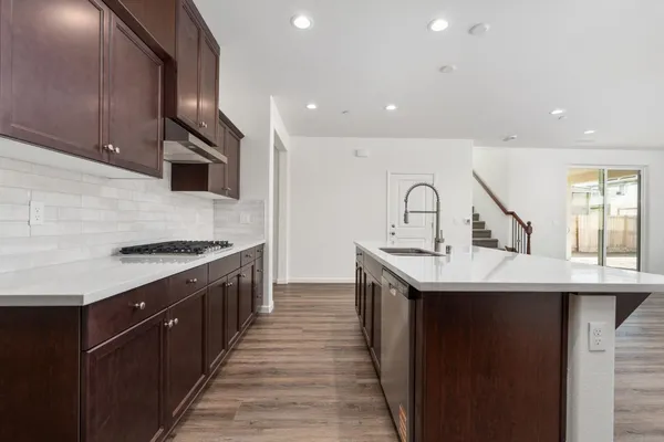 a kitchen with a sink stove top oven and cabinets