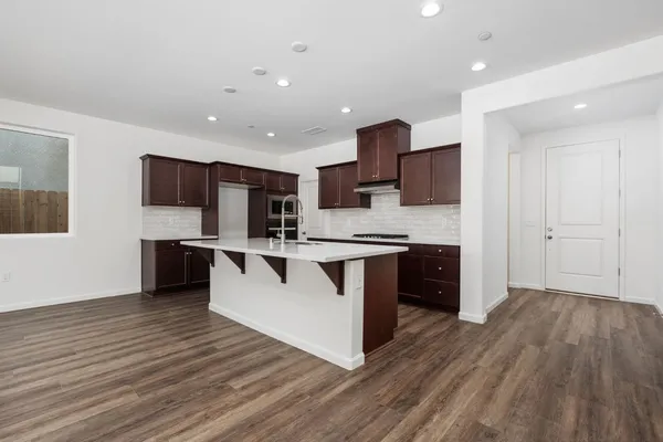 a large kitchen with stainless steel appliances granite countertop a stove a sink and a refrigerator