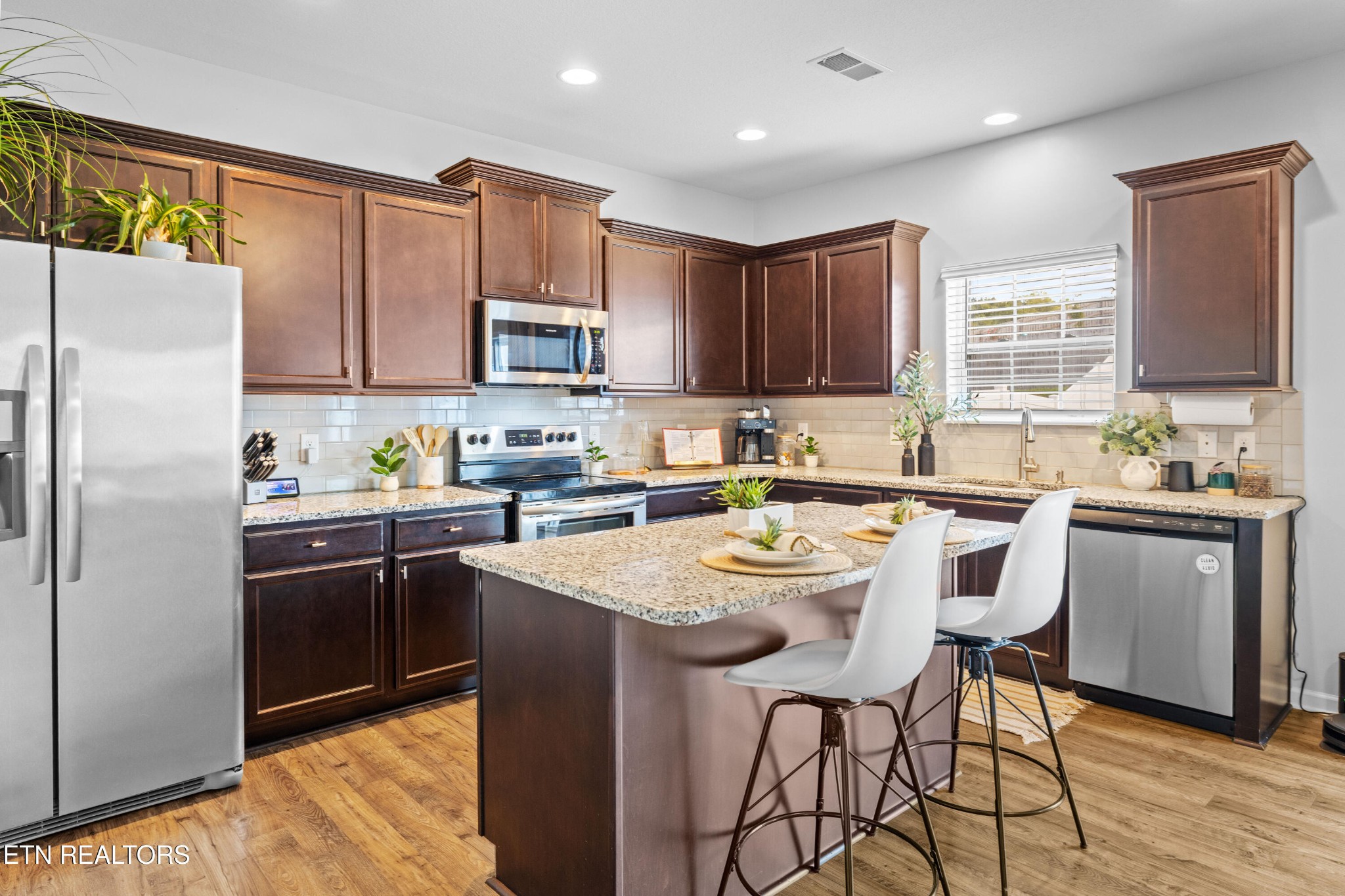 6150 Pembridge Road Knoxville, TN 37912 - Photo 8 of 34 a kitchen with a sink a microwave a refrigerator and cabinets