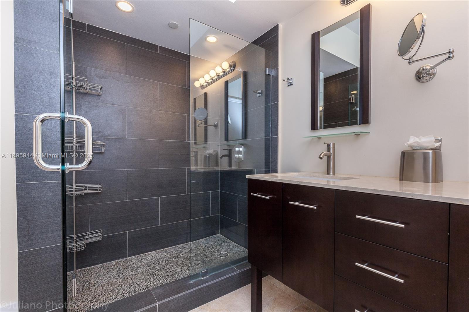 1330 West Avenue, Unit 1613 Miami Beach, FL 33139 - Photo 6 of 20 a bathroom with a double vanity sink a mirror and glass door