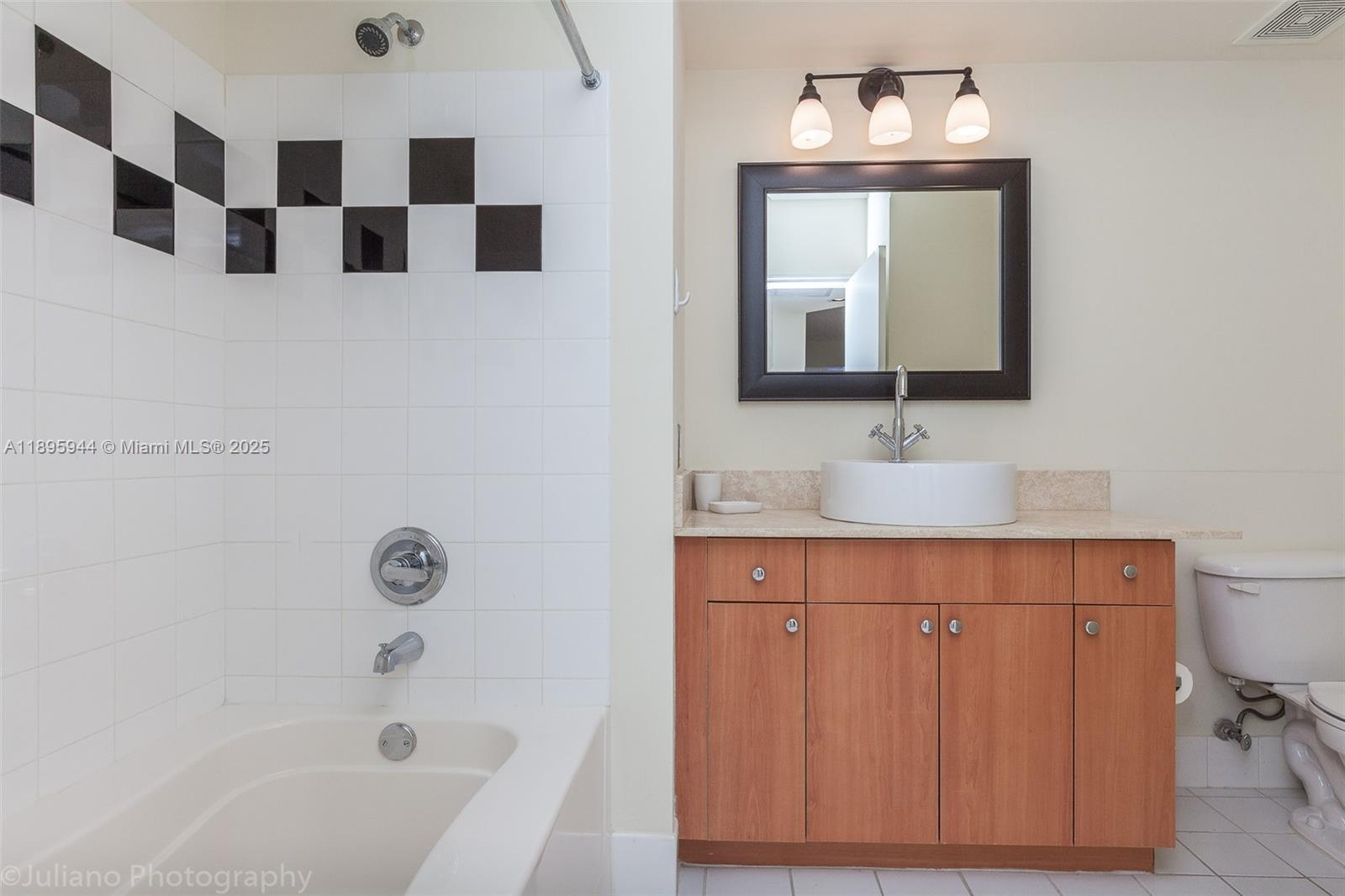 1330 West Avenue, Unit 1613 Miami Beach, FL 33139 - Photo 9 of 20 a bathroom with a sink a large mirror and shower