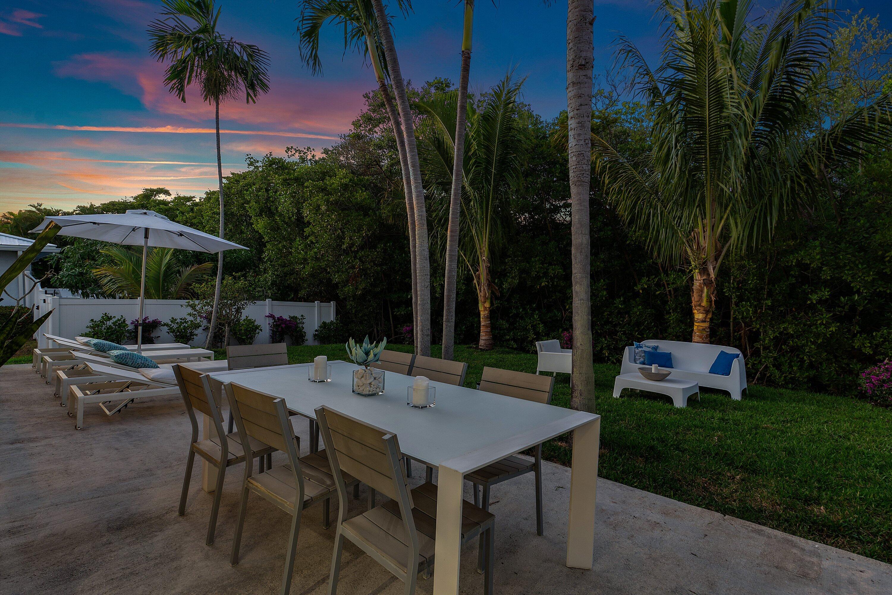 48 Harbour Drive North Ocean Ridge, FL 33435 - Photo 24 of 25 a view of a patio with table and chairs potted plants and palm trees