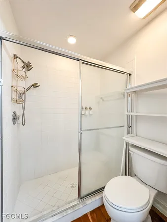 a white toilet sitting next to a shower