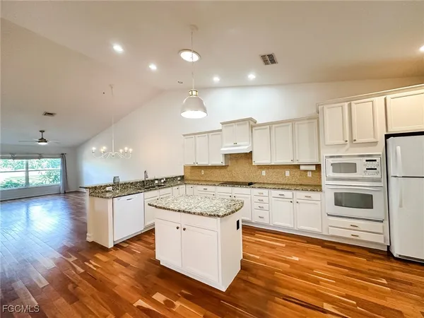 a kitchen with stainless steel appliances granite countertop counter space a sink and a refrigerator
