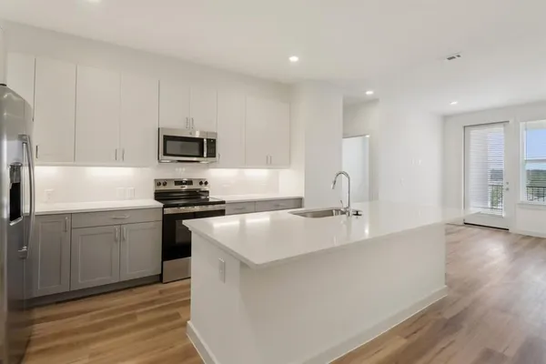 a kitchen with kitchen island a sink stainless steel appliances and cabinets