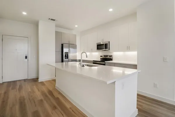 a kitchen with kitchen island white cabinets and stainless steel appliances